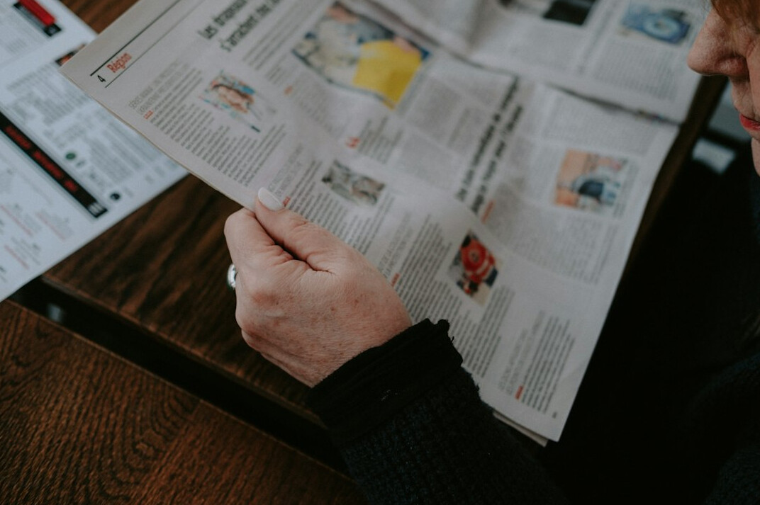 person reading old newspaper